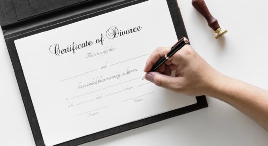 Image of a lady signing a divorce certificate